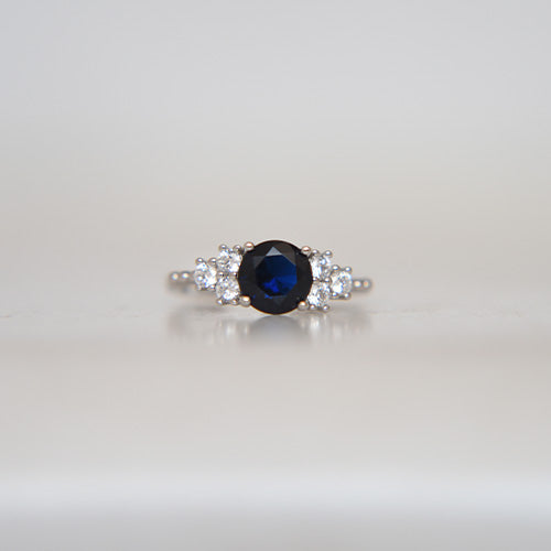 Round Cut Dark Blue Stone With 3 Side Stone Ring